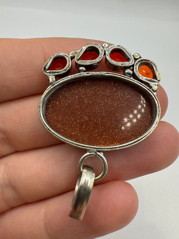 Silver goldstone and topaz pendant