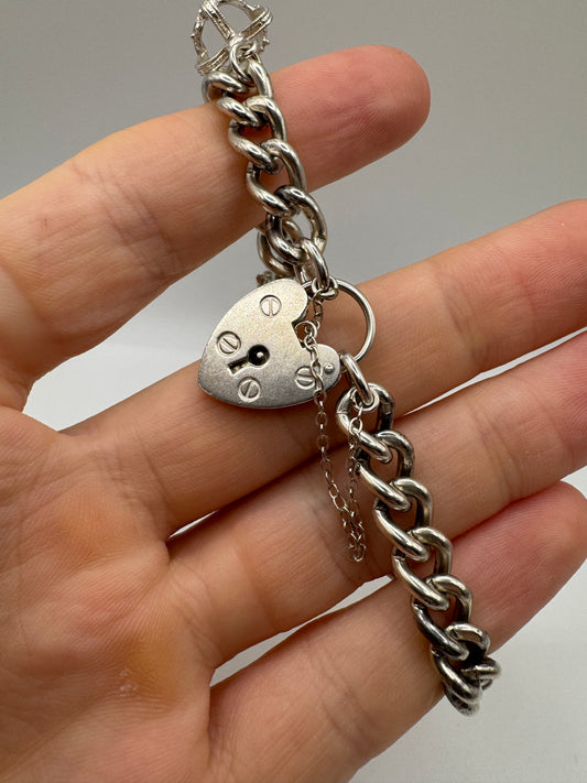 Silver charm bracelet including silver padlock